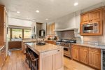 The full kitchen features granite countertops and an island that serves as a breakfast bar for casual meals